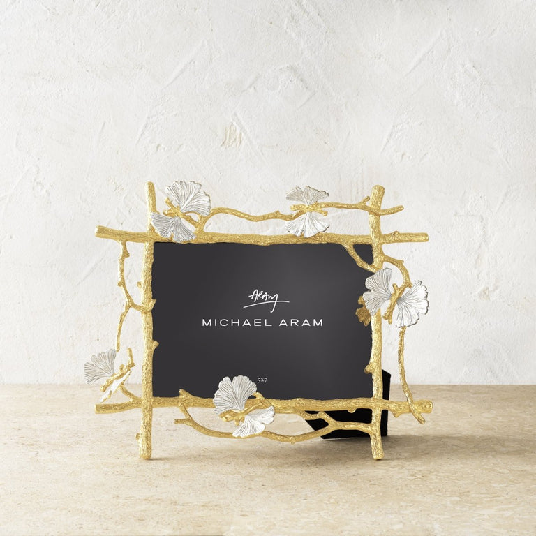 Gold brass butterfly-shaped frame with white enamel finish holding a photo.