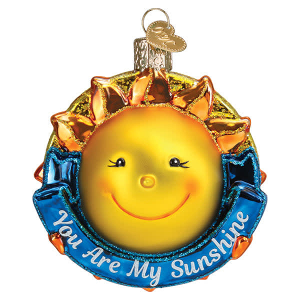 Red glass Christmas ornament shaped like a smiling sun with yellow rays.