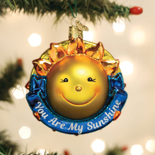 Glass Christmas ornament shaped like a smiling sun with yellow rays.