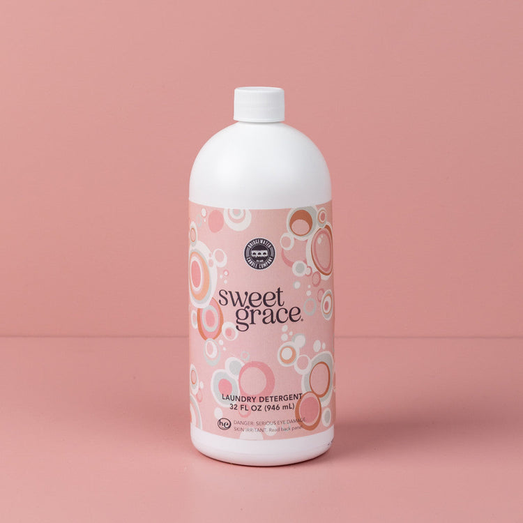 32oz bottle of Sweet Grace laundry detergent with a pink bubble pattern on a pink background.
