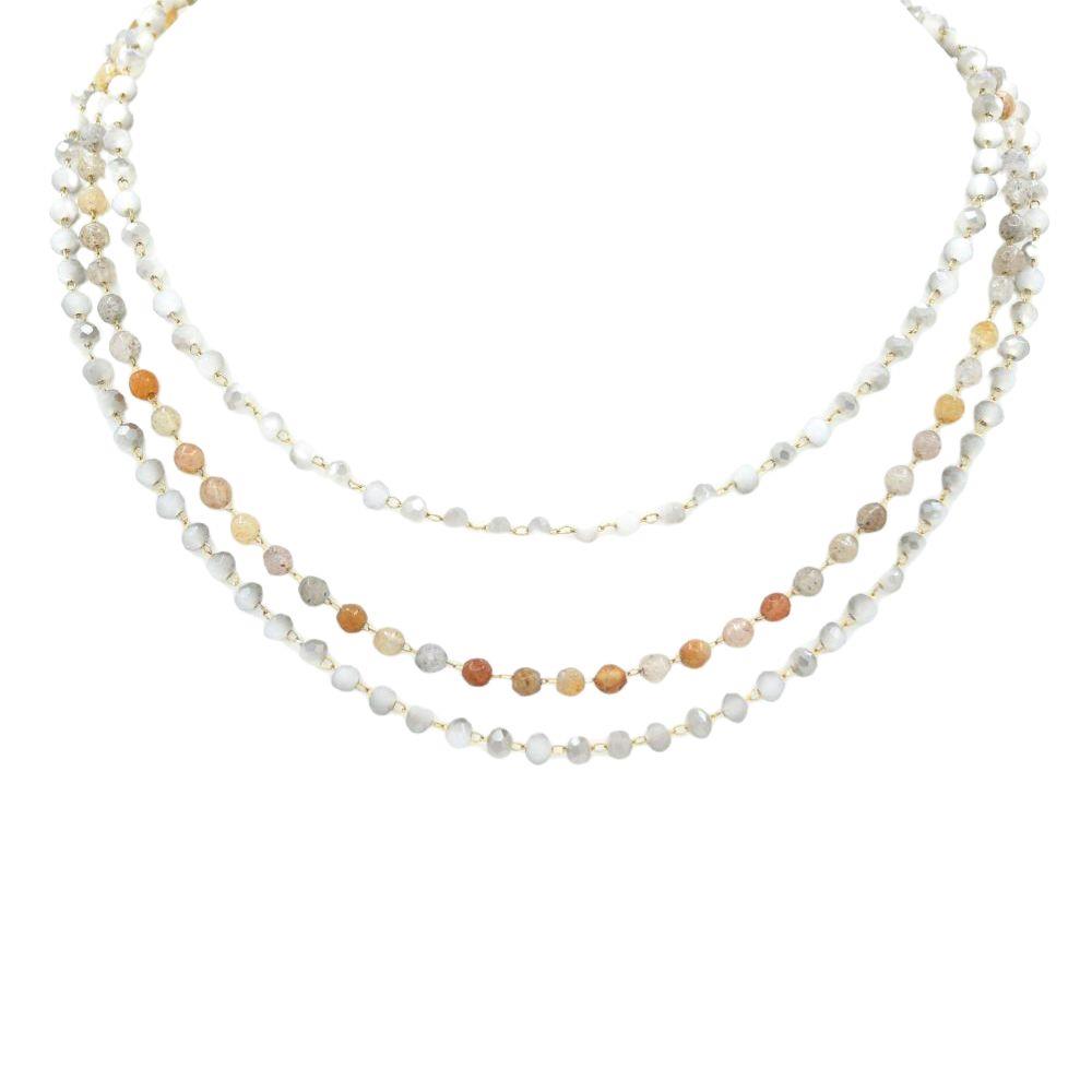 Three-strand beaded layered necklace with faceted stones in white, grey, and amber tones.