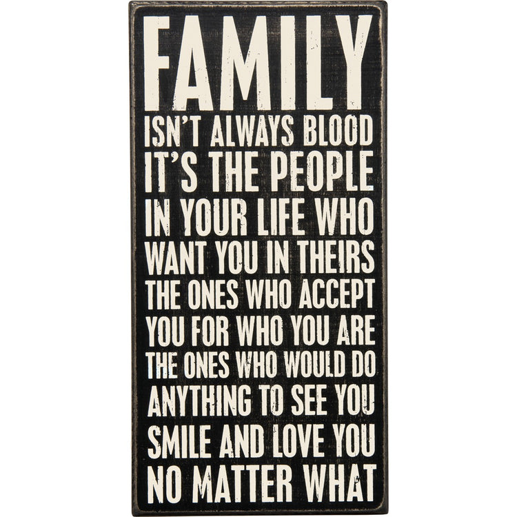 Black wooden box sign with white text reading 'FAMILY ISN'T ALWAYS BLOOD IT'S THE PEOPLE IN YOUR LIFE WHO WANT YOU IN THEIRS'