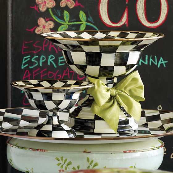 Two Courtly Check enamel compotes in different sizes with a green bow on a matching platter.