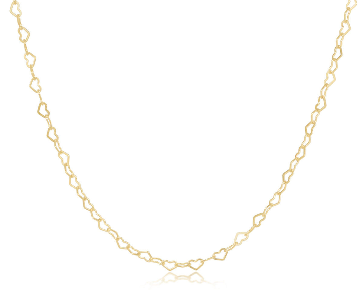 Gold choker necklace with a heart-shaped pendant on an adjustable chain.