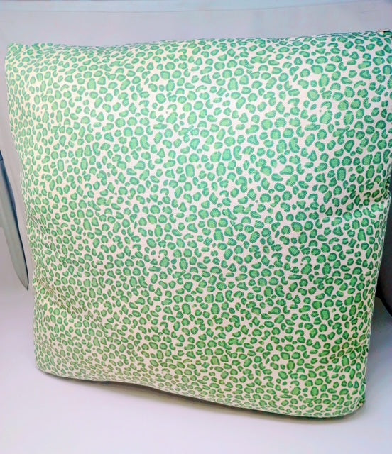A 24x24 inch hand-crafted pillow with a green leopard print pattern on a cream background.
