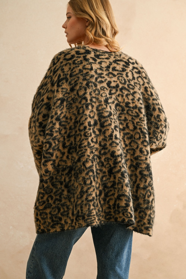 Back view of a woman wearing the Courtney Leopard Oversized Cardigan in a fuzzy knit with blue jeans.