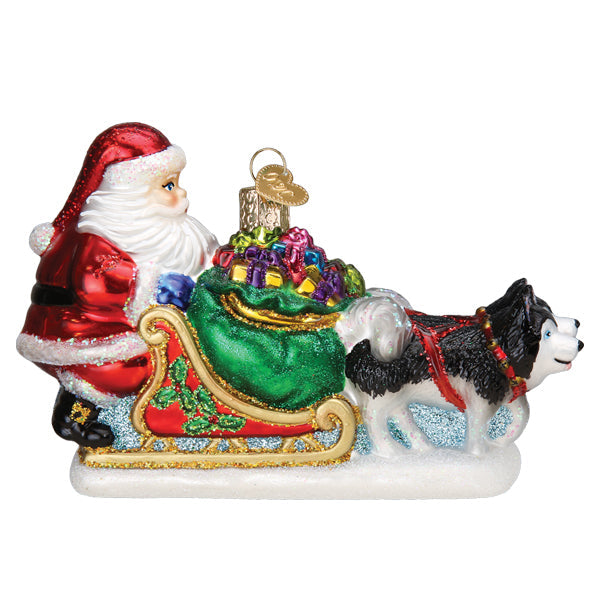 Santa Claus in a red sleigh filled with gifts, pulled by a black and white husky on a snowy base.
