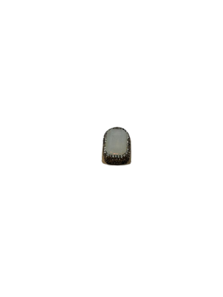 Fashion gemstone ring featuring a rectangular white stone surrounded by a halo of small crystals.