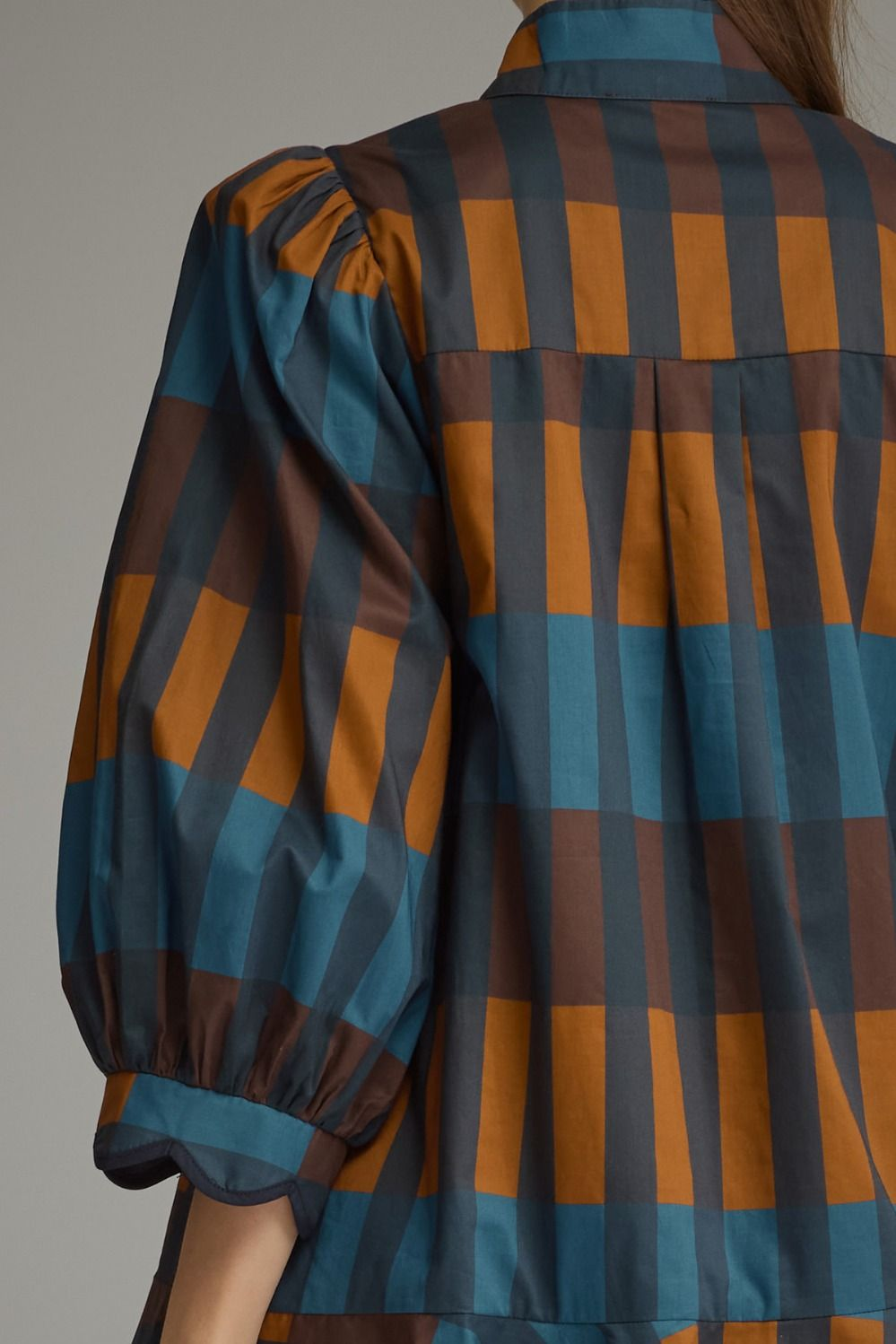 Close-up back view of the Harper Plaid Mini Dress featuring blue and brown checks and balloon sleeve.
