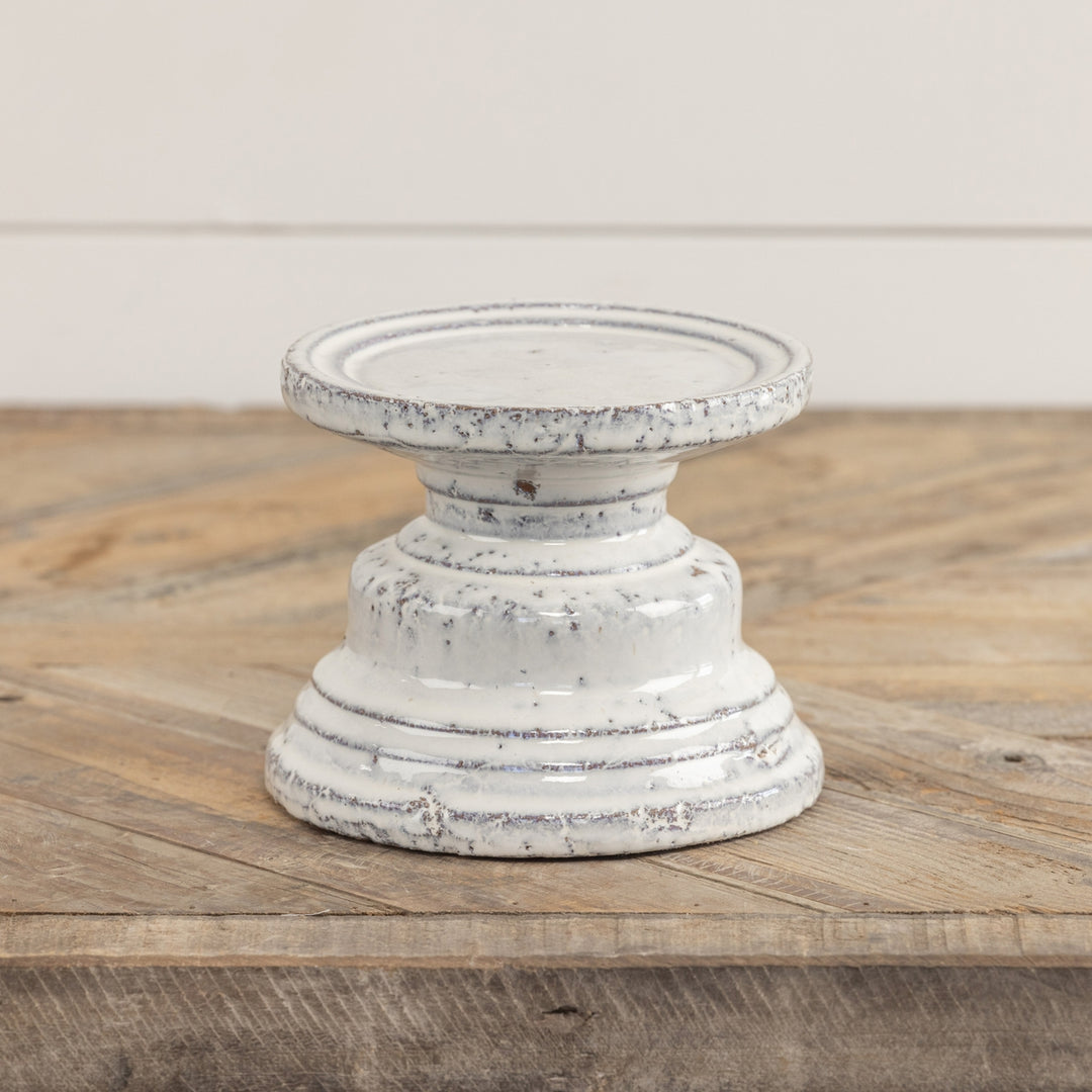 Terracotta cream pillar candle stand with a square four-inch silhouette.