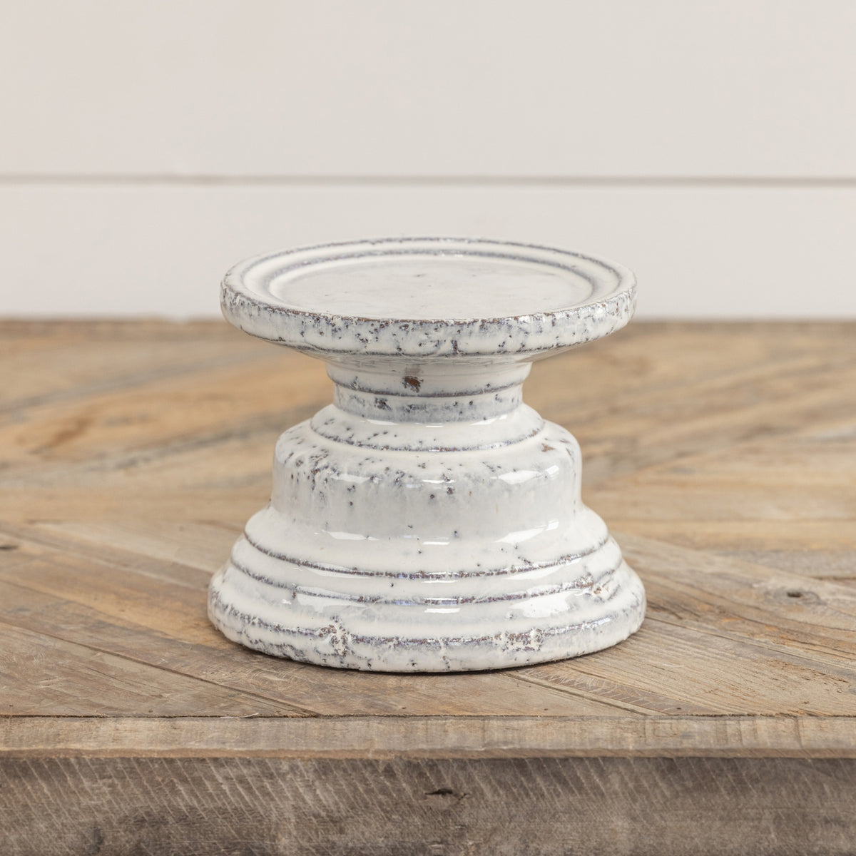Terracotta cream pillar candle stand with a square four-inch silhouette.
