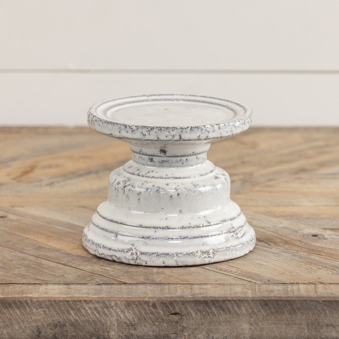 Terracotta cream pillar candle stand with a square four-inch silhouette.