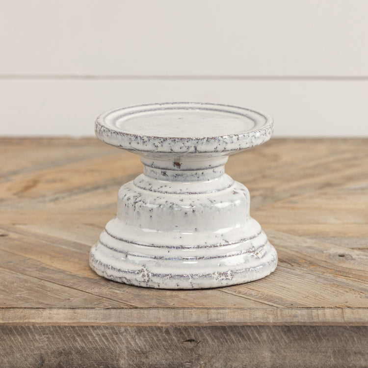 Terracotta cream pillar candle stand with a square four-inch silhouette.