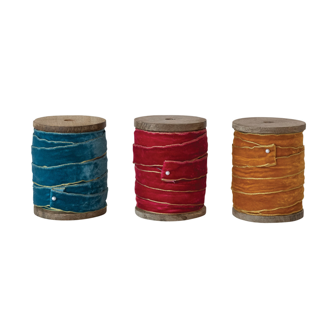Three wood spools with 5 yards of velvet ribbon in teal, red, and gold with metallic gold edges.