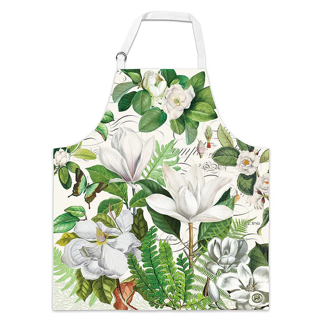 White cotton chef apron featuring a vintage botanical print of white magnolias and green ferns.