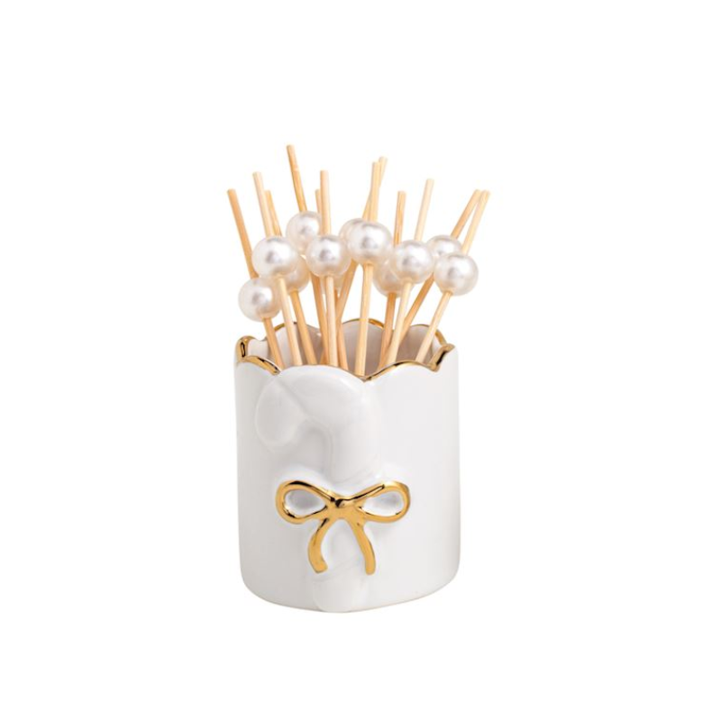 White stoneware toothpick caddy with gold-edged candy cane motif and pearl-topped wooden toothpicks.