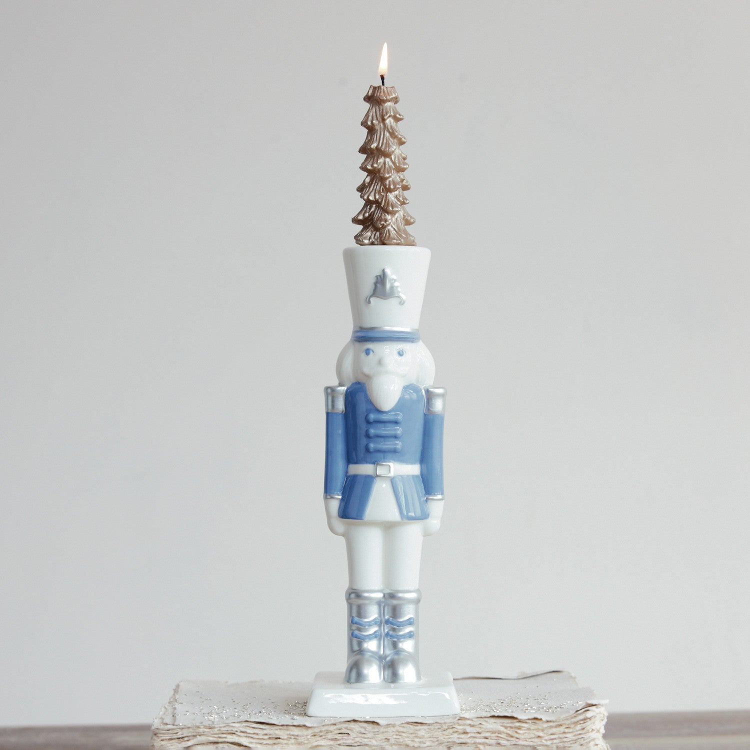 White and blue ceramic nutcracker taper candle holder with silver electroplating details.