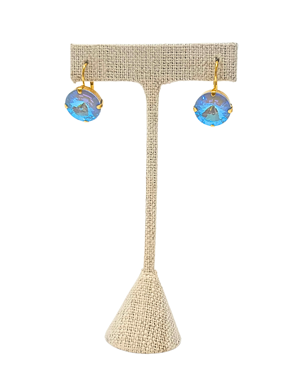 Caitlin Round Earrings with blue crystals and antique gold plating on a jewelry display stand.