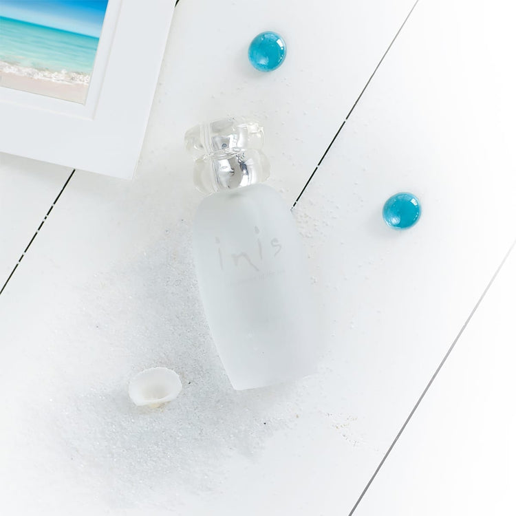 Frosted glass bottle with pebble-shaped cap containing Inis Cologne Spray.