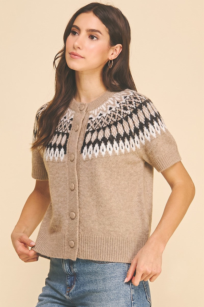 Woman wearing a beige Jessica Nordic short sleeve knit cardigan with a black and white yoke pattern.