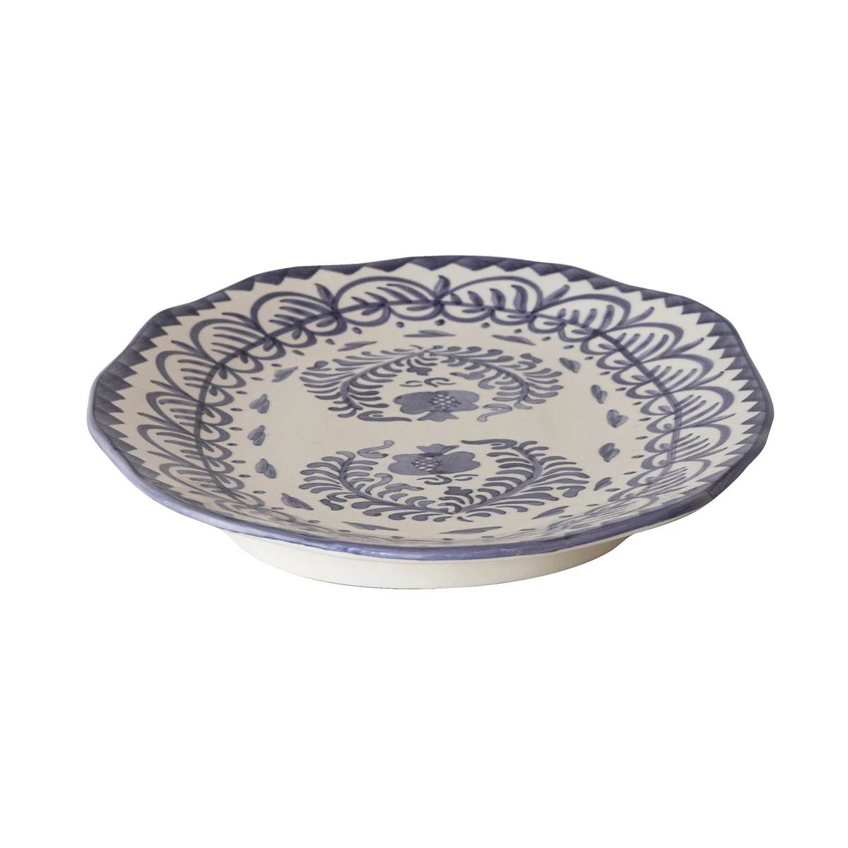 Hand-painted blue-and-white stoneware platter with organic free-form silhouette and botanical pattern.