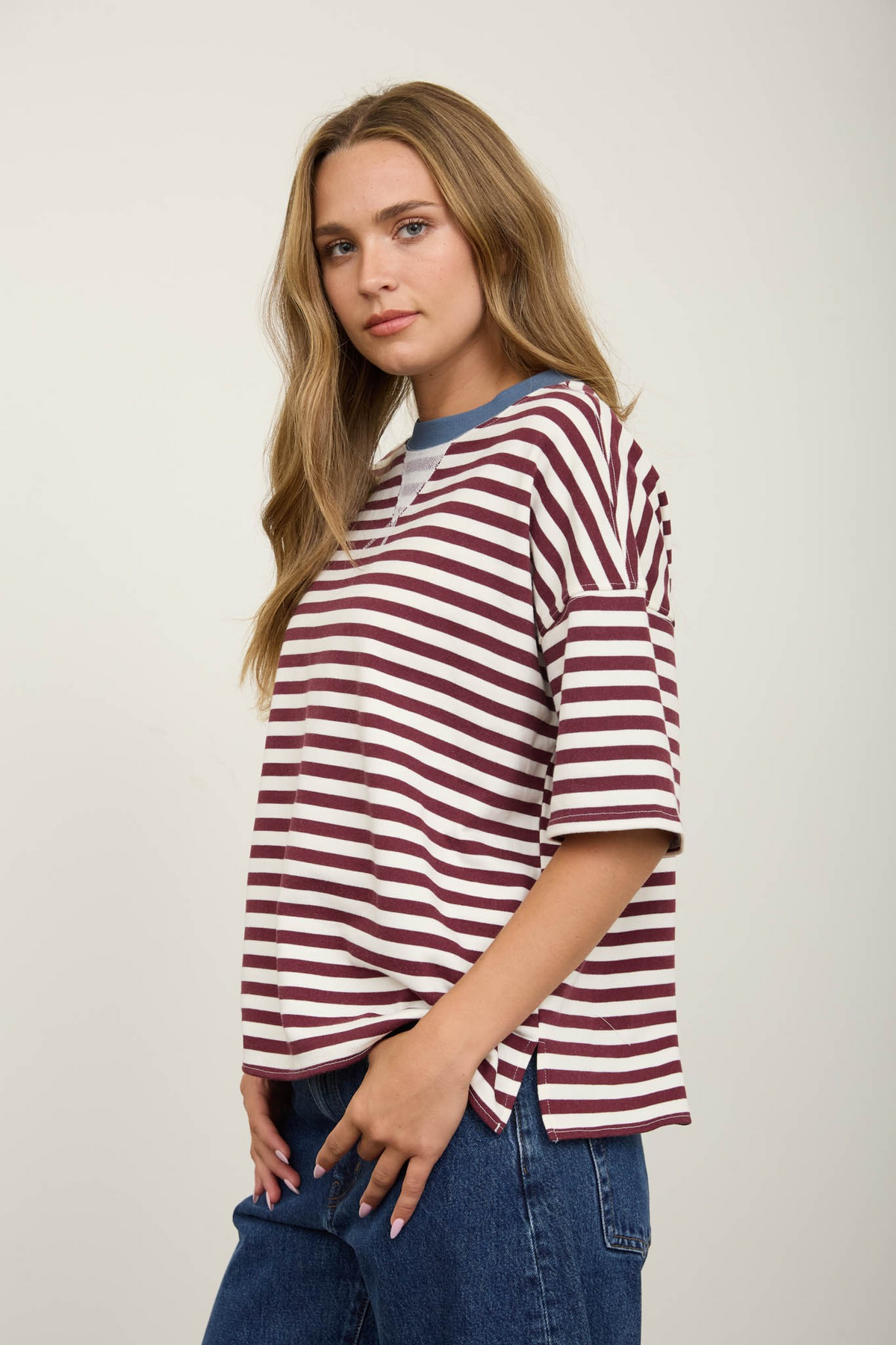 Woman wearing a burgundy and white striped short sleeve knit t-shirt with a blue contrast collar.