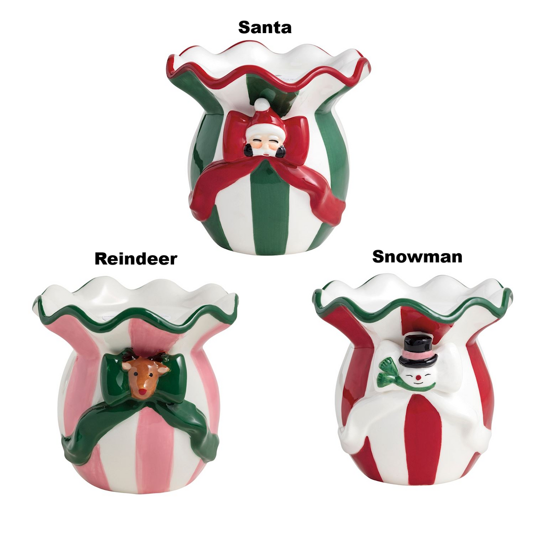 Three striped ceramic Christmas pillar candle holders featuring Santa, Reindeer, and Snowman bows.