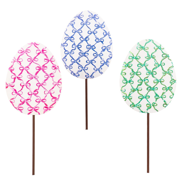 Bowtiful Eggs stake featuring a white egg-shaped body with colorful bow patterns.