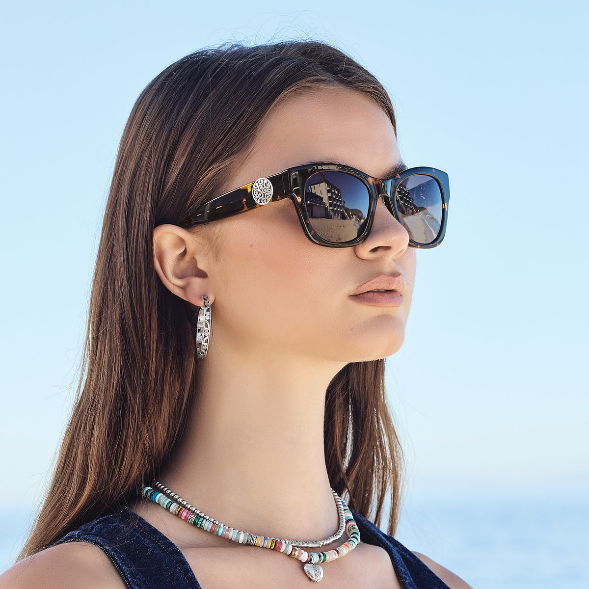 Woman wearing tortoise cat eye Contempo Medallion Sunglasses with silver plated accents.