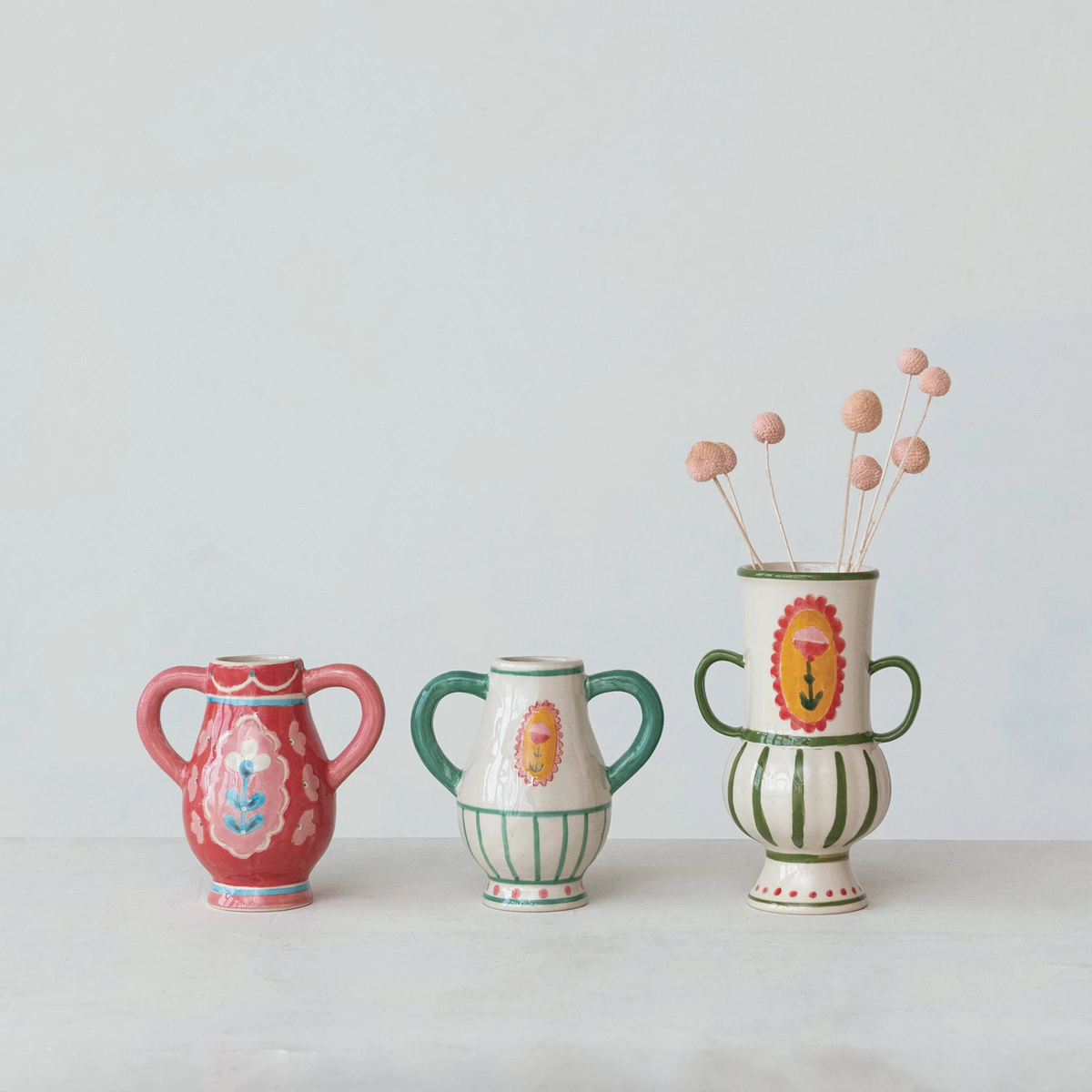 Hand-painted stoneware vase with handles in earthy tones featuring a floral silhouette.