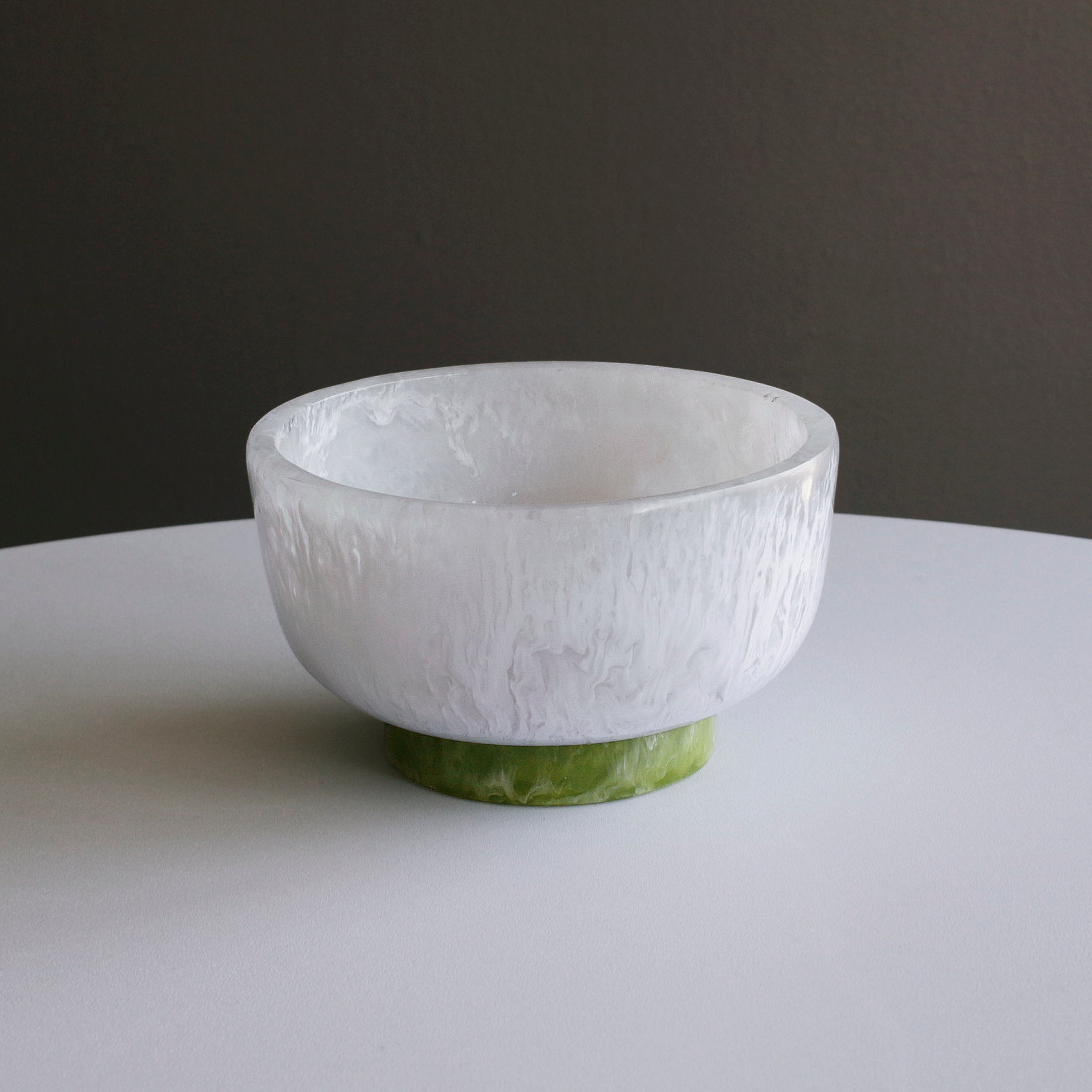 RESIN Rio Small Bowl with a marbled white body and a contrasting green base on a white surface.