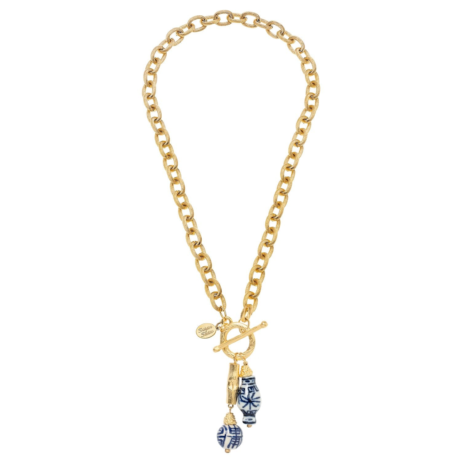 Gold chain necklace with a toggle closure and blue and white porcelain bamboo-style charms.
