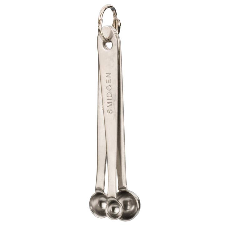 Set of three stainless steel measuring spoons labeled Smidgen, Pinch, and Dash on a metal ring.