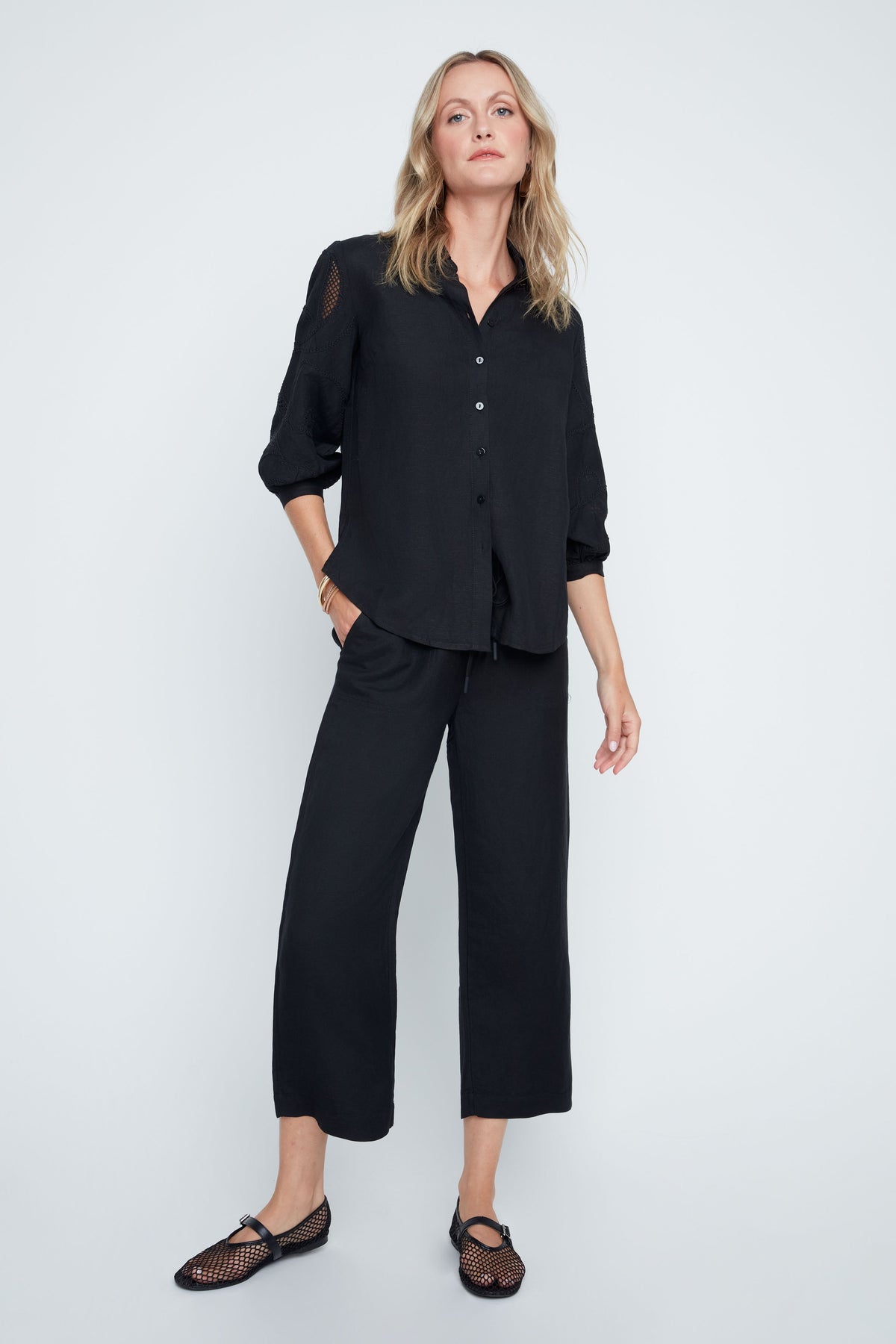Hannah woven blouse in soft neutral tone with relaxed fit, button front, subtle textured sleeves, and sheer panel accents.