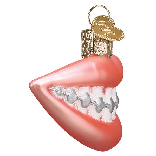 Glass Christmas ornament shaped like a smiling mouth with pink lips and silver braces on white teeth.