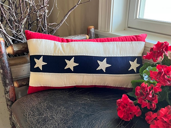Vintage red, white, and blue stars and stripes bolster pillow with a classic American flag pattern.