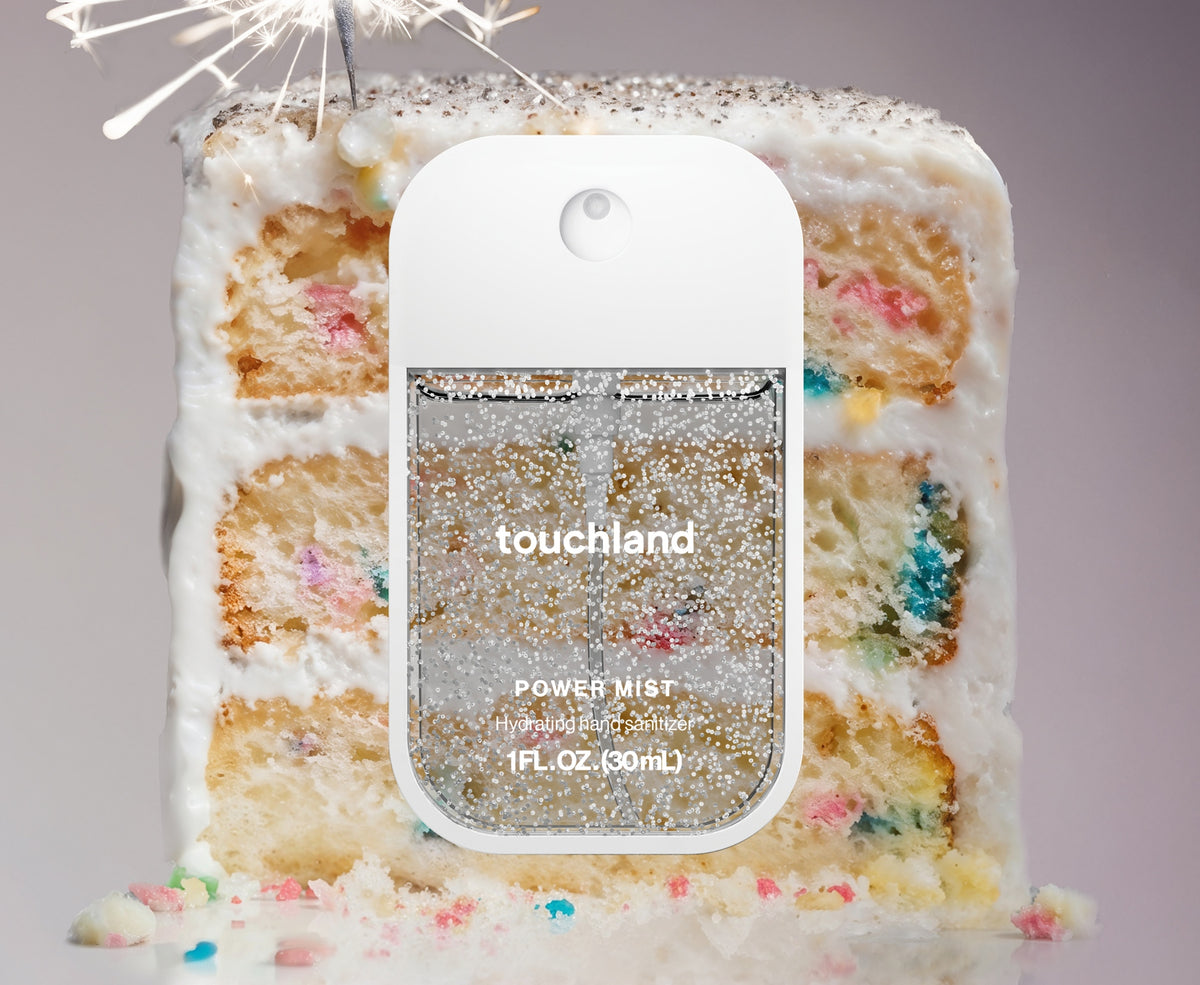 Touchland Confetti Cake Power Mist hand sanitizer in a white bottle with rainbow sprinkles and vanilla bean design.