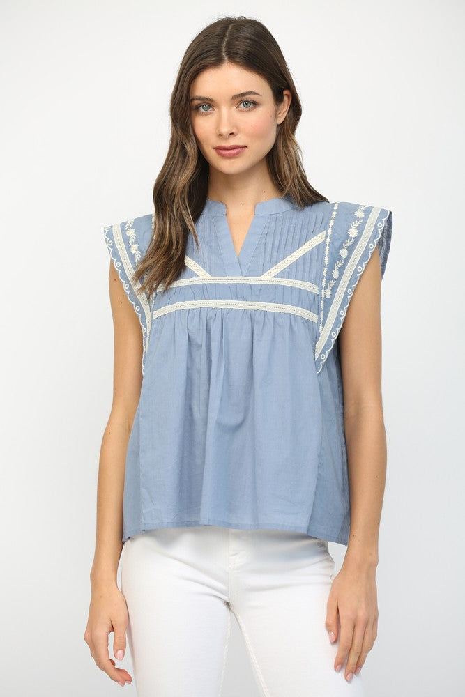 Leah ruffle sleeve cotton blouse featuring tape accents and embroidery on a light-colored background