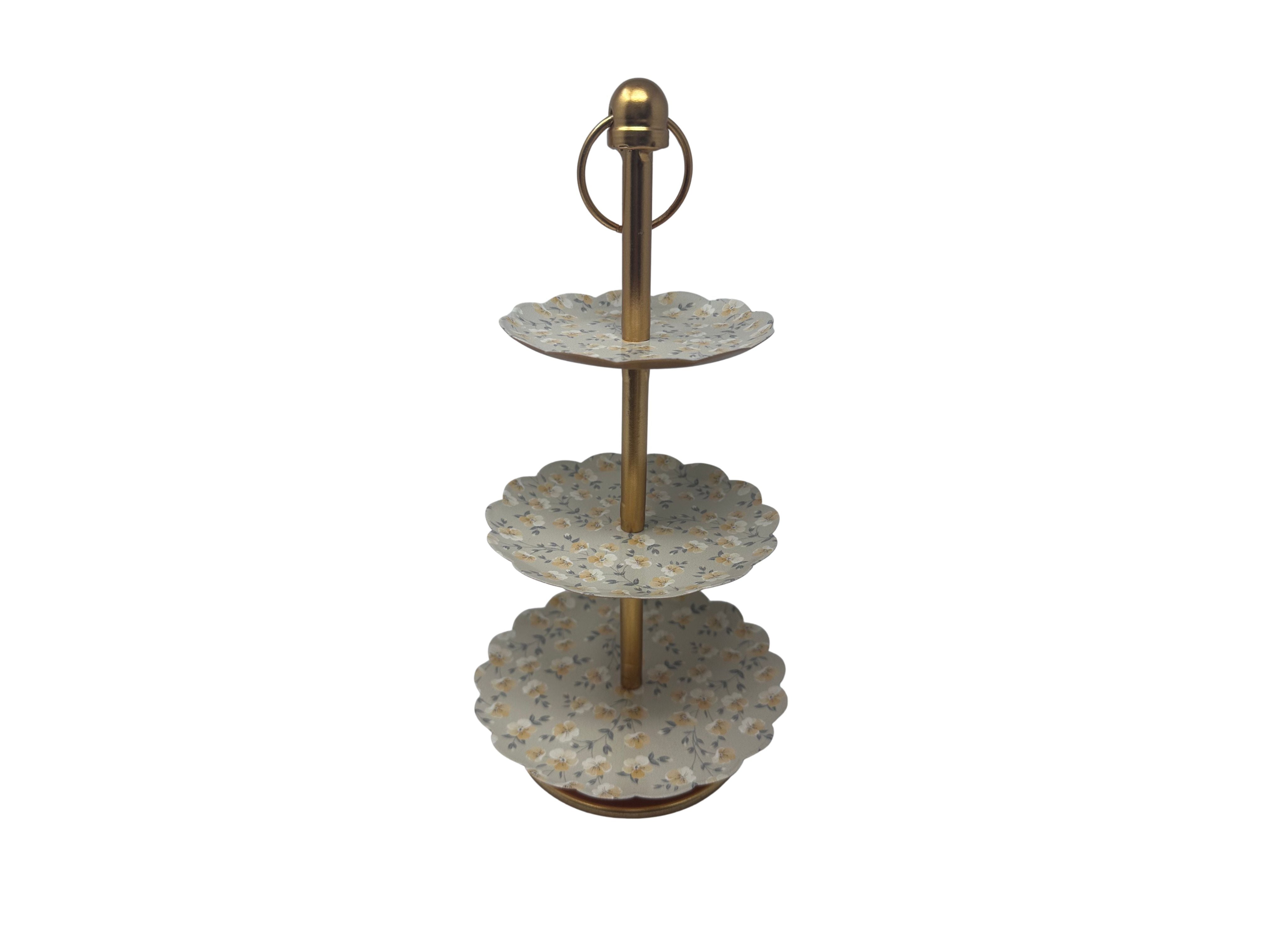 Three-tier tray with floral pattern plates and a gold-finished center post and ring handle.