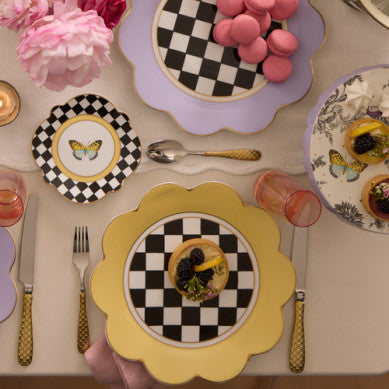 Buttercream Petal Dinner Plate with a scalloped yellow rim and black and white checkered center.