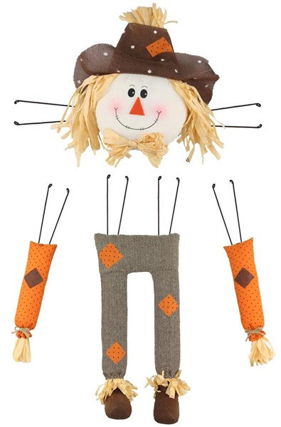 Scarecrow Decor Kit with a smiling head, orange arms, and grey pants with straw accents.