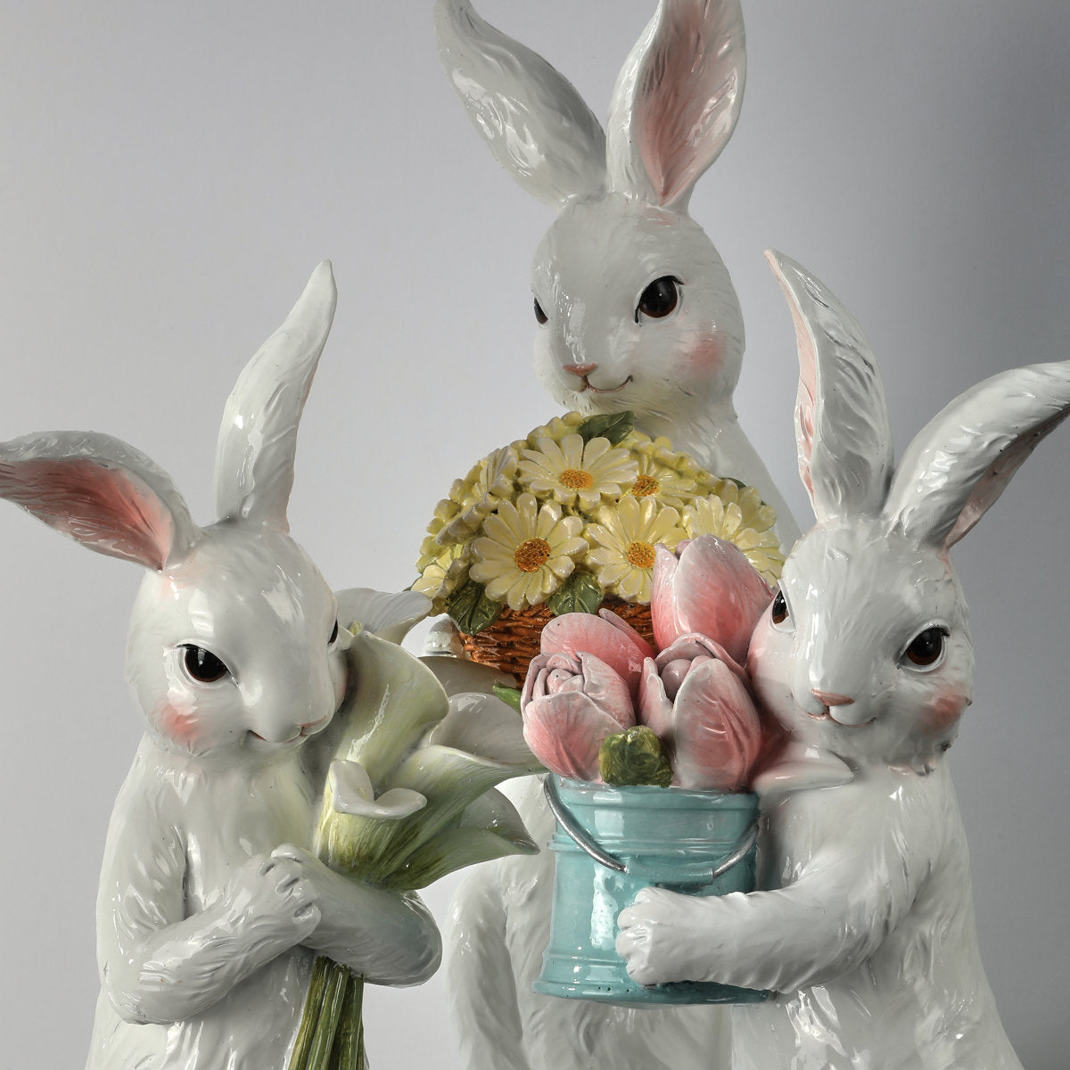 Resin bunny figurine holding a floral bouquet with pastel colors