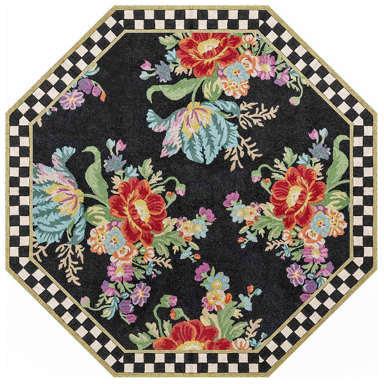 Octagonal black rug with colorful floral bouquets and a black and white checkered border.