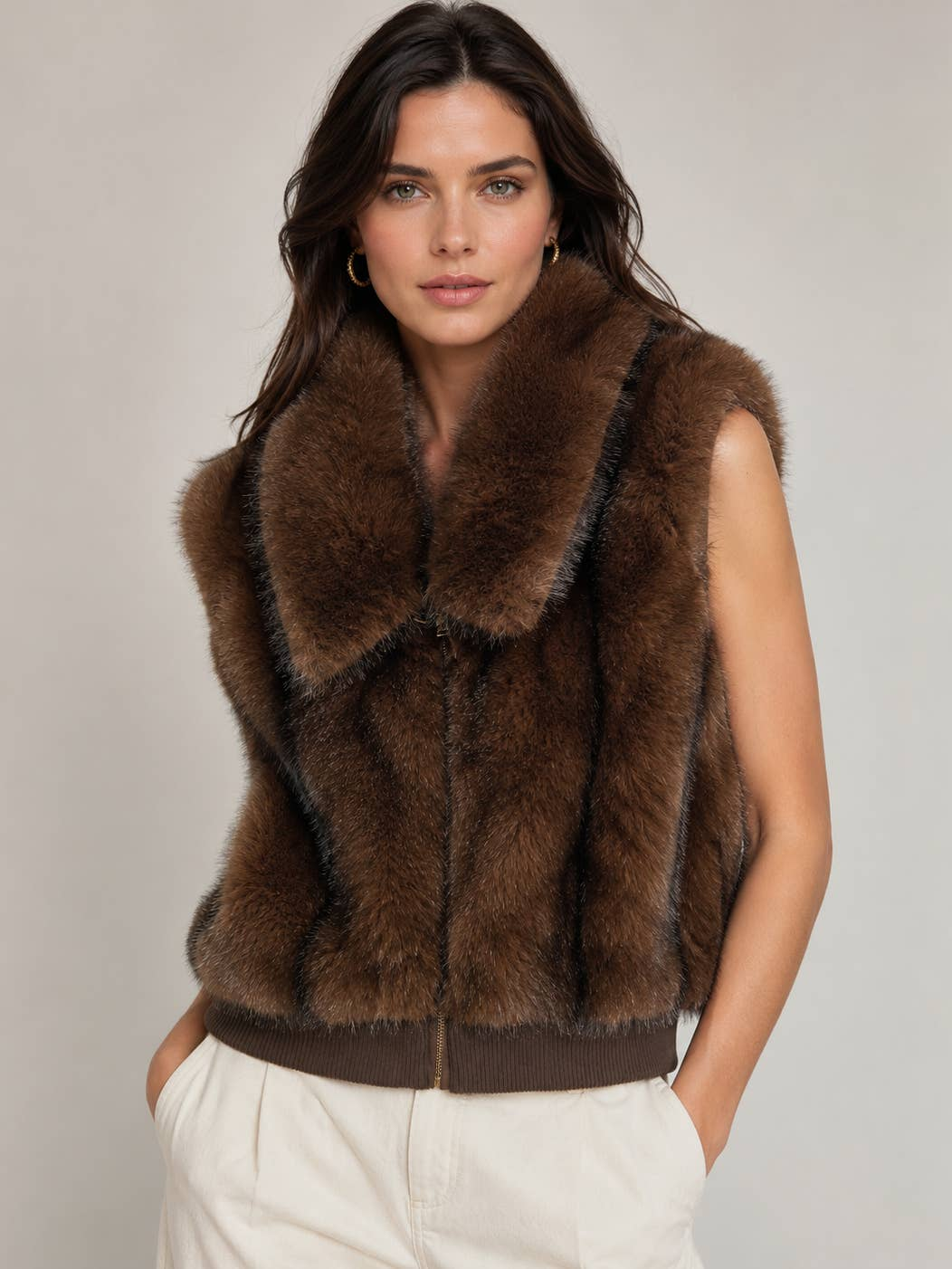 Woman wearing a brown Jenny Fur Bomber Zip Up Vest with a statement collar and rib-knit waistband.