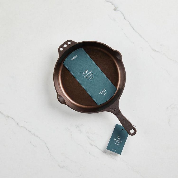 Top view of a No. 10 Traditional Skillet with a polished interior on a white marble surface.