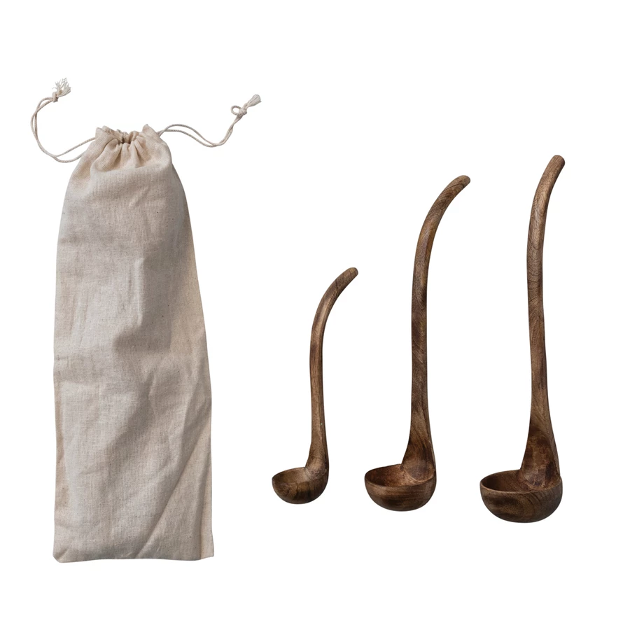 Set of three mango wood ladles in varying sizes with a walnut finish and a cream drawstring bag.