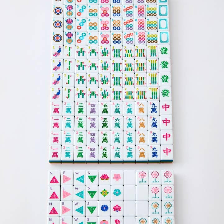 La Fete Mahjong Tiles in olive green, baby pink, and teal with hand-painted symbols and characters.