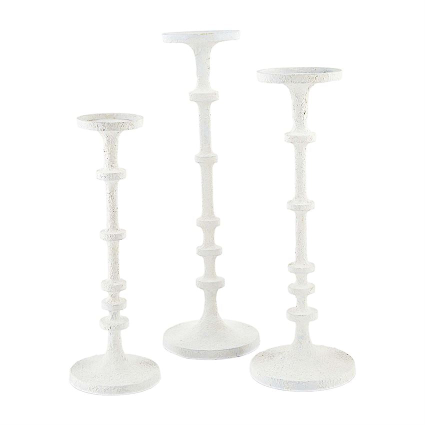 Two white metal candlesticks with a sleek cylindrical shape.