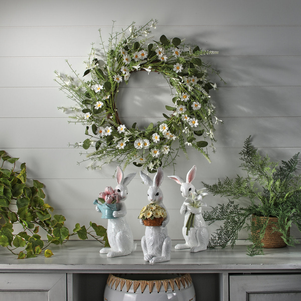 Resin bunny figurine holding a floral bouquet with pastel colors.