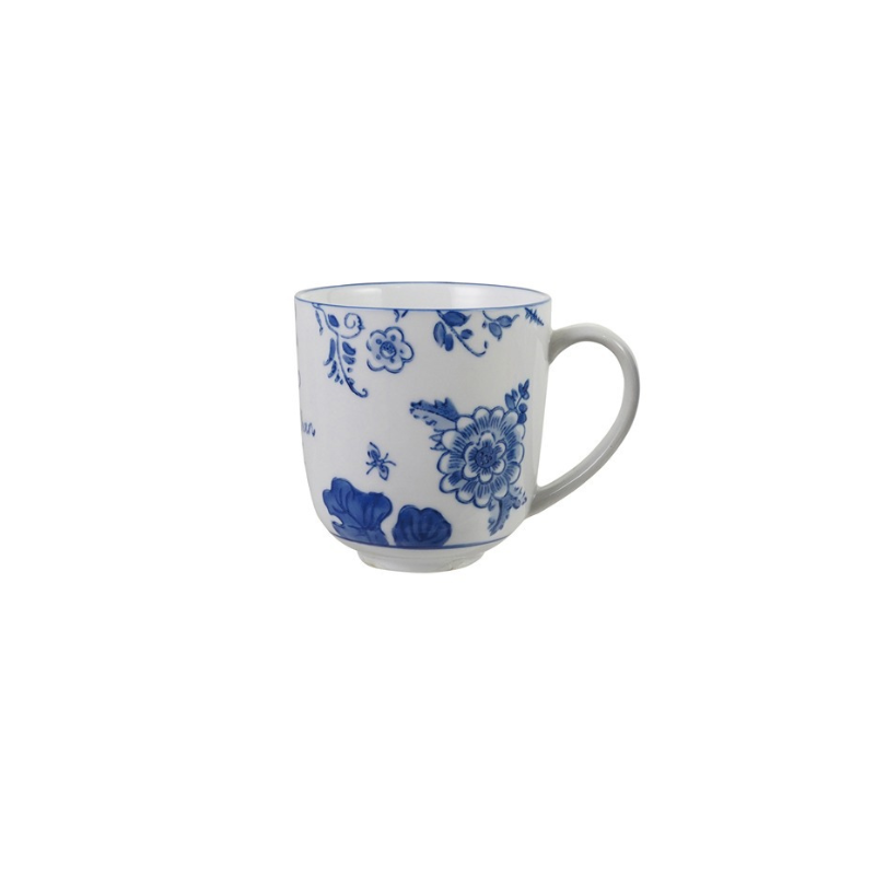 White stoneware mug with blue floral patterns and a curved handle.